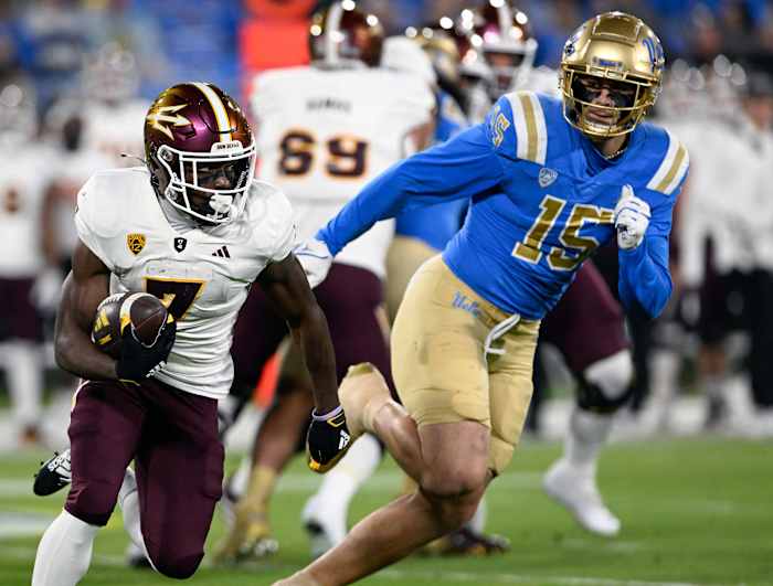 Nov 11, 2023; Pasadena, California, USA; Arizona State Sun Devils wide receiver Melquan Stovall (7) runs against UCLA Bruins defensive lineman Laiatu Latu (15) at the Rose Bowl. Mandatory Credit: Alex Gallardo-USA TODAY Sports  